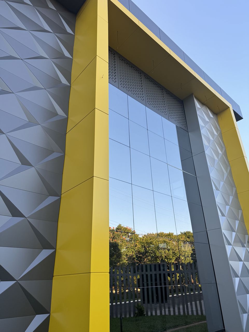Faceted ACM panels beside a yellow returned frame