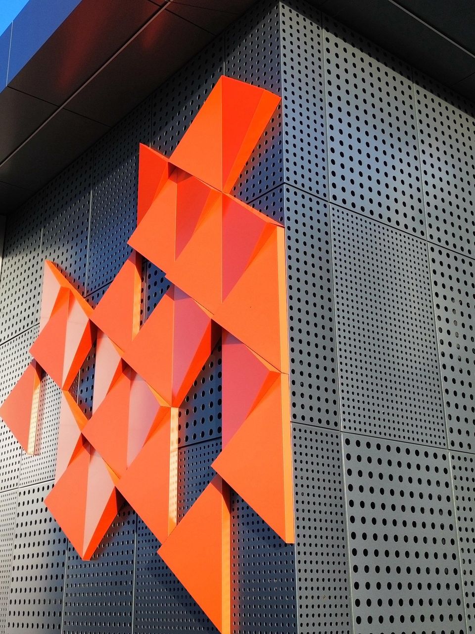 Orange folded pieces on perforated sheets
