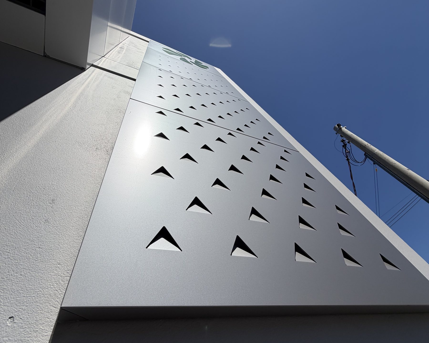 Perforated ACM sheet seen at an angle against the sky