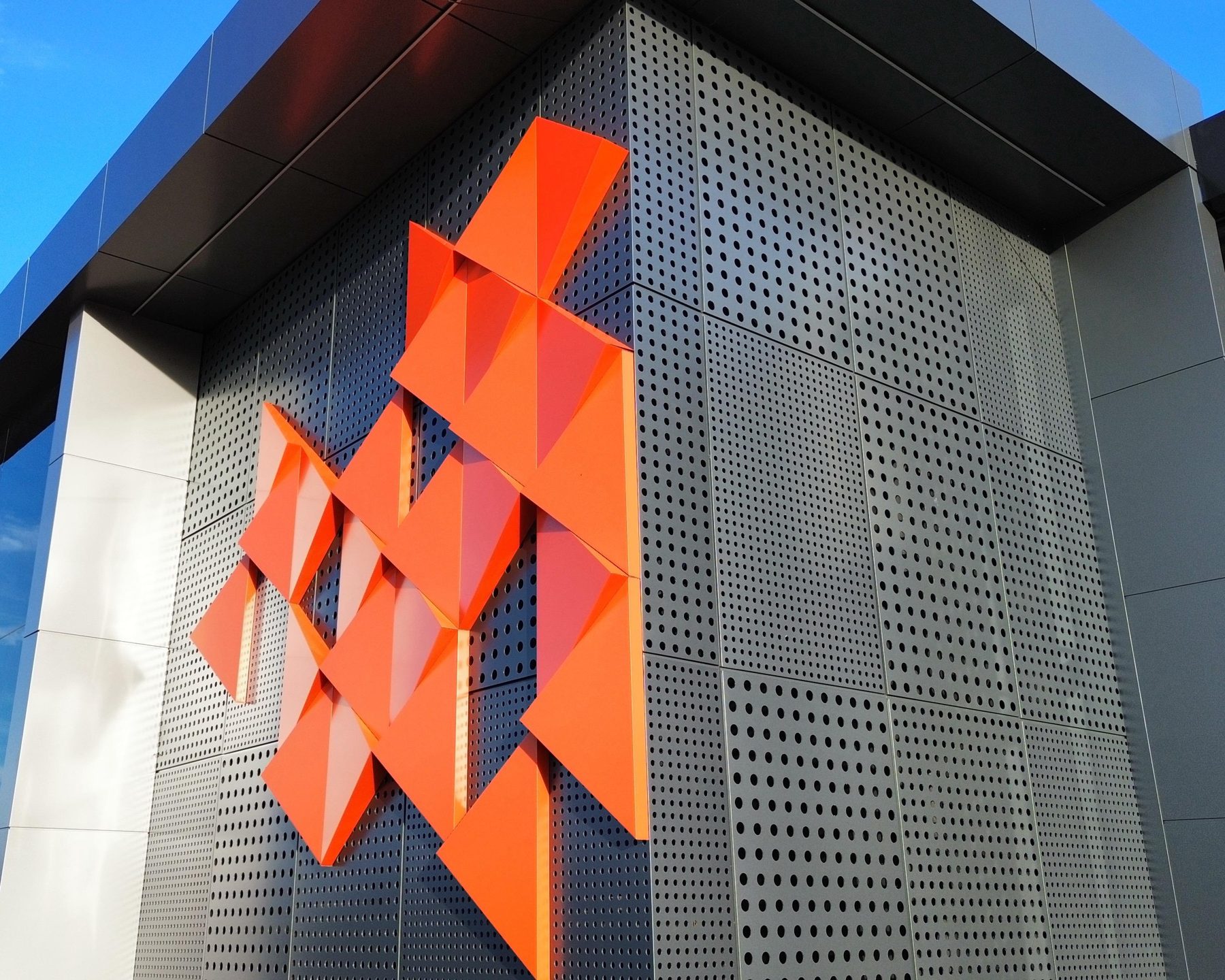 Orange folded pieces on perforated sheets