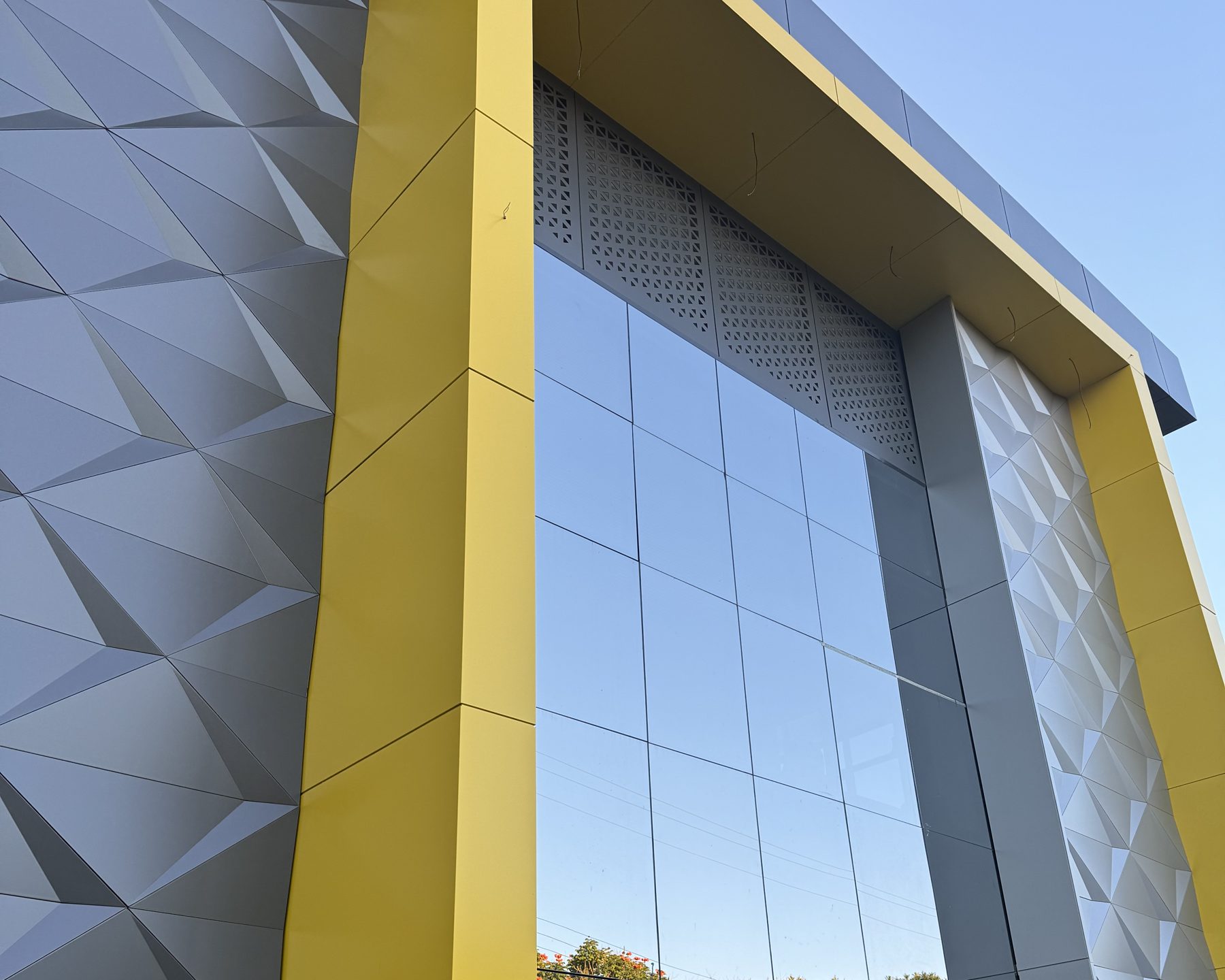 Faceted ACM panels beside a yellow returned frame